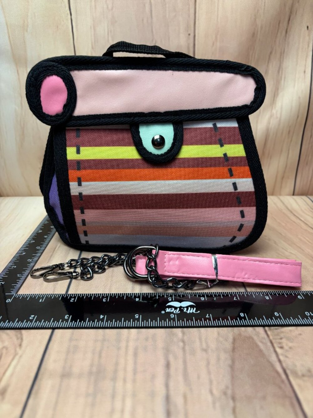 Small handbag featuring a colorful striped design in several colors.